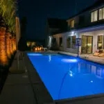 The elements of water and fire are combined in this landscaping project in Washington, Utah. While out front, the landscape is dominated by easy-to-care-for artificial turf.