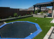 St. George synthetic turf rebates can help yiou install artificial grass like this for a fraction of the cost, anywhere in Washington County! We surrounded this newly installed pool with an amazing landscape that was complemented by a beautiful gazebo installed after our work was completed. The trampoline, artificial turf, and sand pit provide areas for the kids to play while the shade of the gazebo and the pool provide a place for grownups to relax and enjoy and evening with friends.