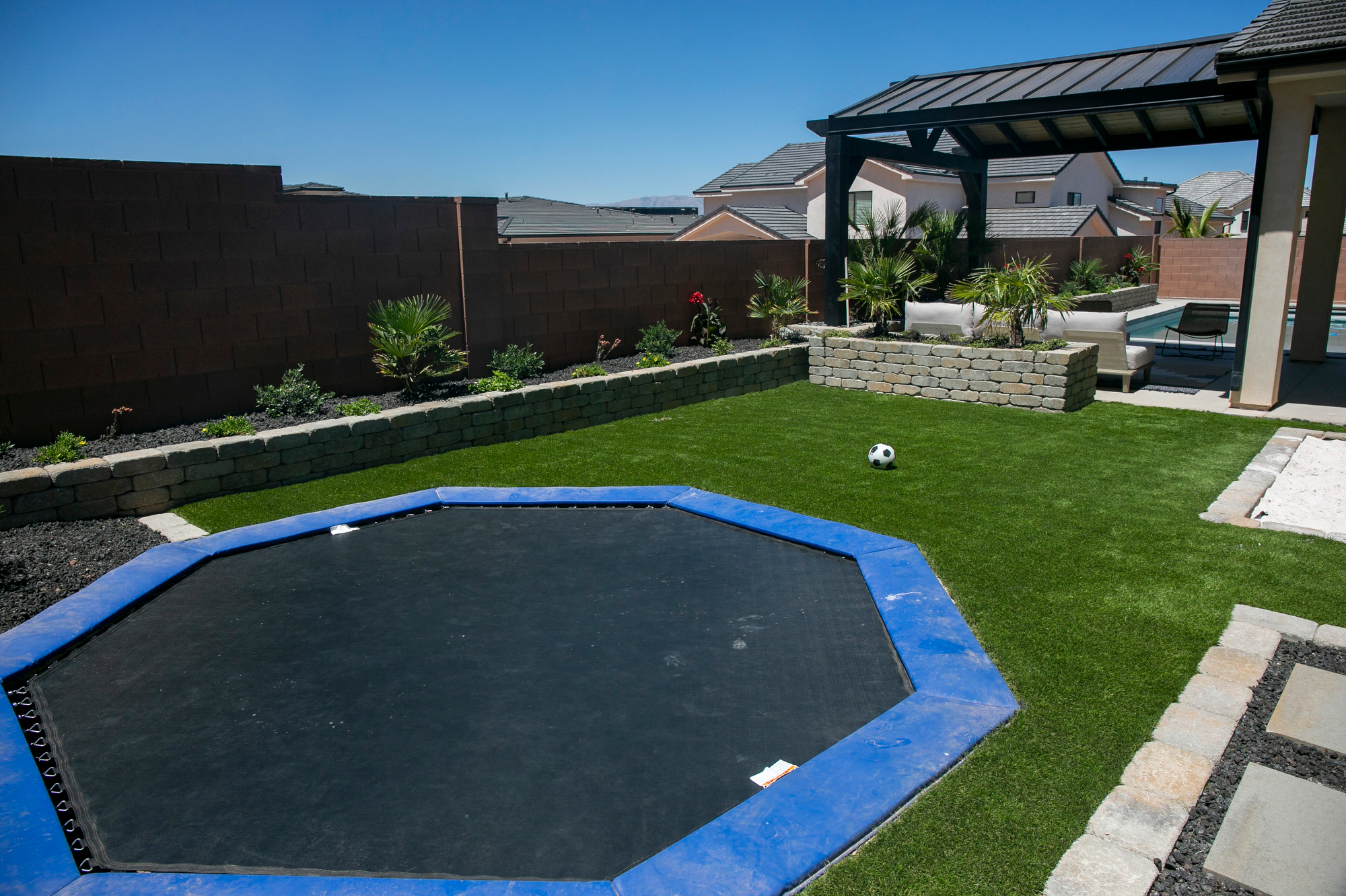 St. George synthetic turf rebates can help yiou install artificial grass like this for a fraction of the cost, anywhere in Washington County! We surrounded this newly installed pool with an amazing landscape that was complemented by a beautiful gazebo installed after our work was completed. The trampoline, artificial turf, and sand pit provide areas for the kids to play while the shade of the gazebo and the pool provide a place for grownups to relax and enjoy and evening with friends.
