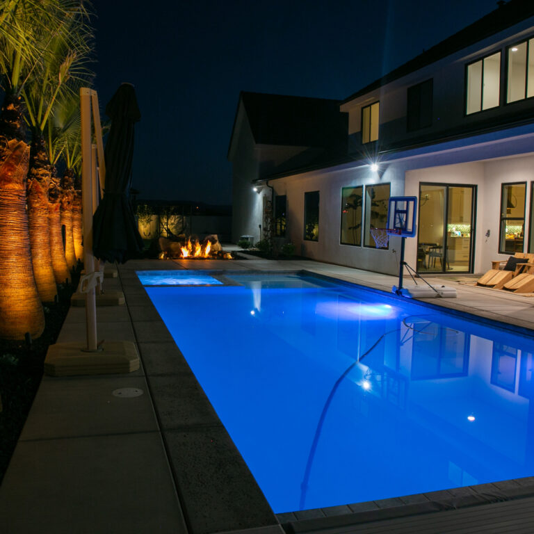 The elements of water and fire are combined in this landscaping project in Washington, Utah. While out front, the landscape is dominated by easy-to-care-for artificial turf.